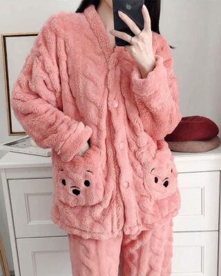 Cute pink woman's fleece pajamas worn by a woman in front of a buffet in a house