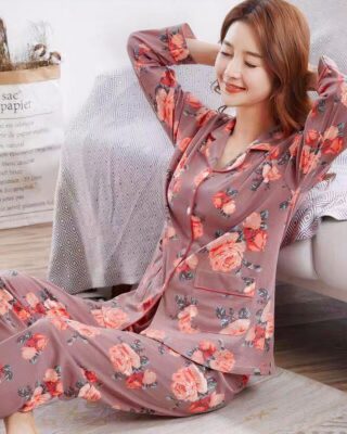 Women's two-piece cotton pajamas with floral pattern, worn by a woman sitting on a carpet in a house