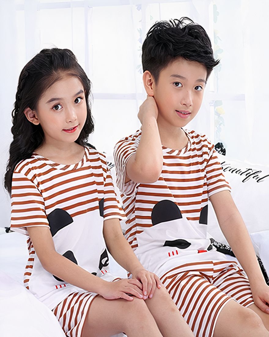 Brown and yellow striped summer pajamas with panda print for children worn by children sitting on a bed in a house