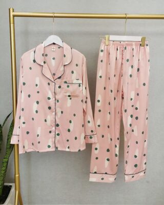 Women's two-piece pink long-sleeved pajamas on a hanger in a house