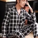 Long sleeve plaid pajamas for men with a man wearing the pajamas with a background a kitchen