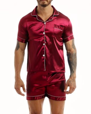 Pyjamas in red satin worn by a man tattooed on his left arm, the pyjamas are composed of shorts and a shirt with buttons on the front