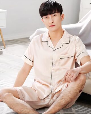 Men's short sleeve satin pajamas with folded collar with a man wearing the pajamas in the sofa