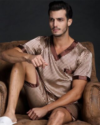 Short sleeve silk satin pajamas for men brown with a man wearing the pajamas on the sofa