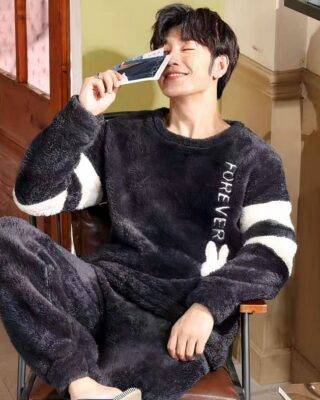 Men's warm fleece pajamas worn by a man sitting on a chair in a fashionable house