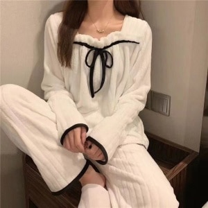 White fleece pajamas for woman worn by a woman in a house
