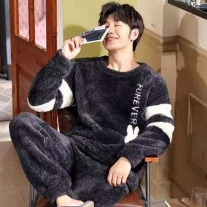 Men's warm fleece pajamas worn by a man sitting on a chair in a fashionable house