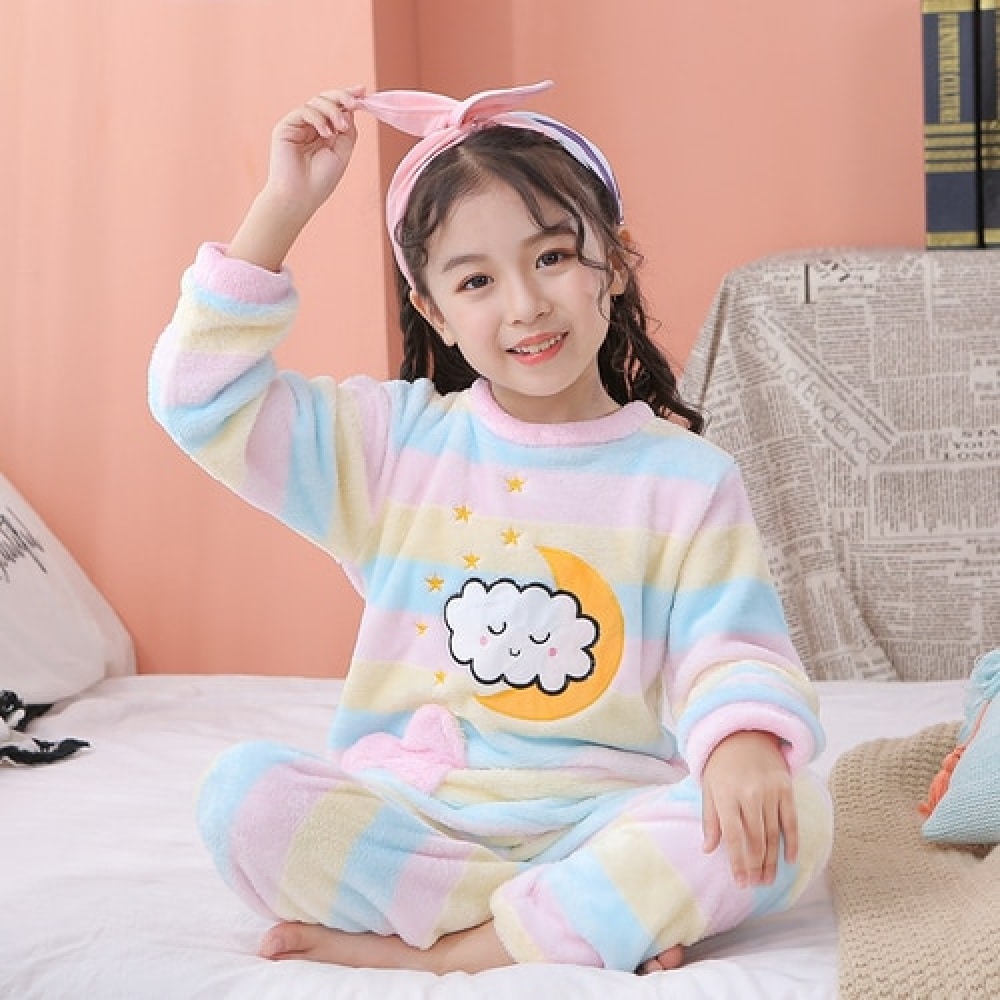 Rainbow colored fleece pajamas for children worn by a little girl on a bed in a house
