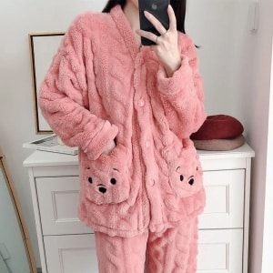 Cute pink woman's fleece pajamas worn by a woman in front of a buffet in a house