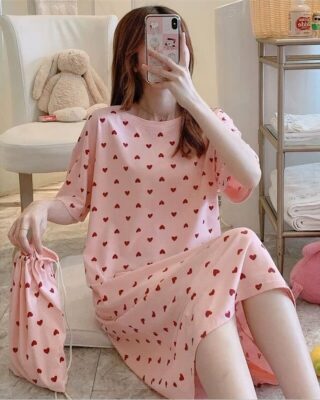 Short sleeve nightgown with heart print worn by a woman sitting on a carpet in a house