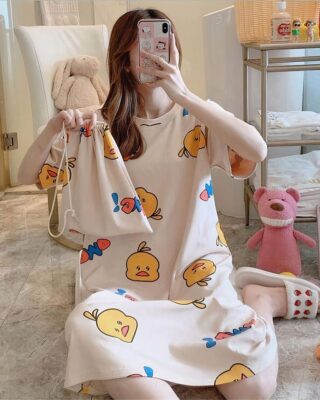 Pyjama nightgown with cartoon print for women worn by a woman sitting on a carpet in a house