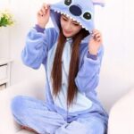 Stich one-piece fleece pajamas. The front of the belly is in light blue color while the rest is in darker blue. On the hood there are the eyes, the nose and the ears of Stich and on the edge of the hood there are the teeth.