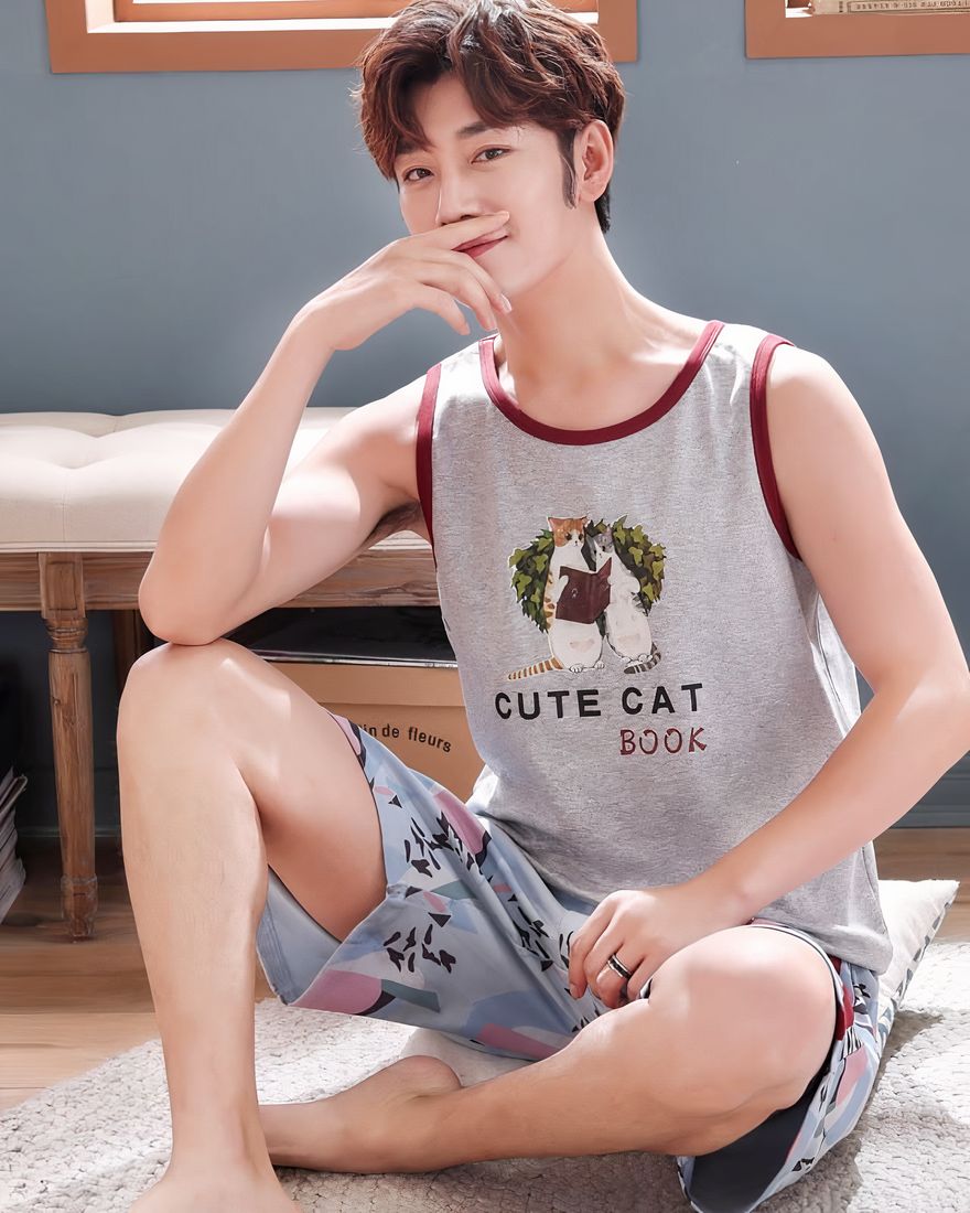 Sleeveless cotton cat pajamas for men worn by a man sitting on a carpet
