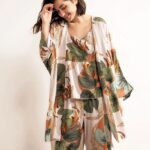 Bohemian flower pajamas composed of three pieces, a pair of pants, a jacket and a strapless top, has floral printed patterns and is worn by a young woman