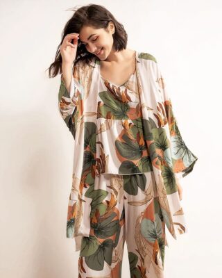 Bohemian flower pajamas composed of three pieces, a pair of pants, a jacket and a strapless top, has floral printed patterns and is worn by a young woman