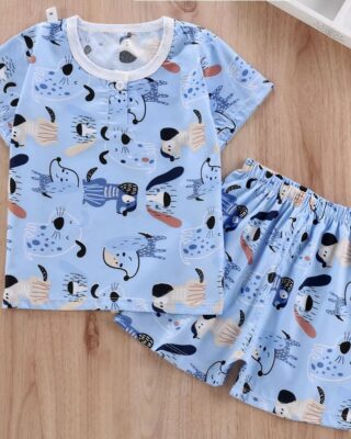 Two-piece summer pajamas for young children in blue with cute patterns and a wooden background