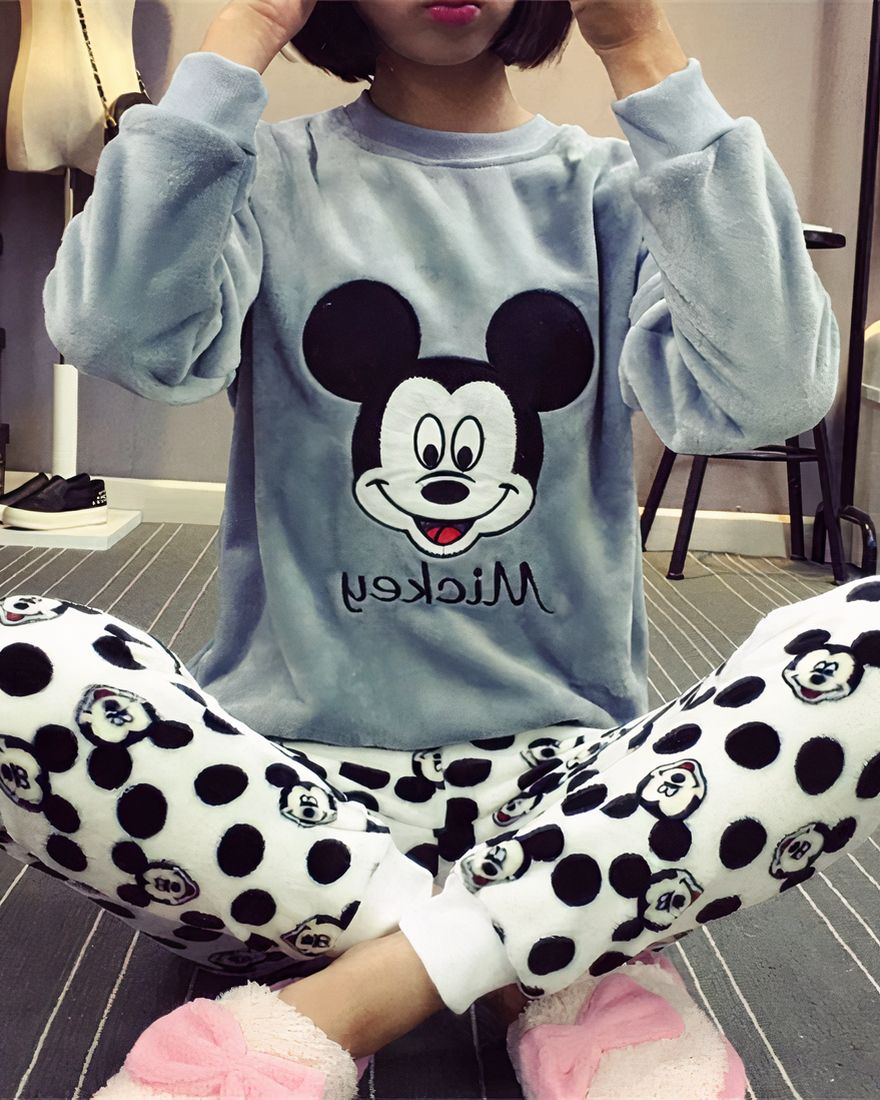 Pyjamas two pieces with the effigy of Mickey, the top is a gray sweater with the head of Mickey and the bottom is a pair of pants composed of head of Mickey black, it is worn ar a young woman