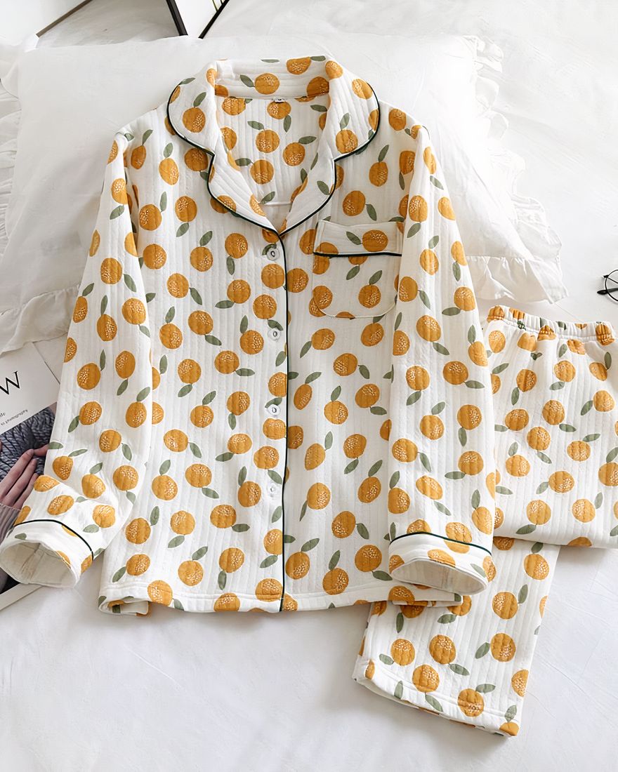 Long sleeve cotton pajamas with orange print and a flower leaf on the side with a small magazine