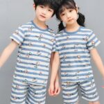 White pajamas with blue stripes for children with two children, a girl and a boy who protect the pajamas