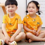 Yellow two-piece pajamas with cartoon pattern for children with two small children wearing the pajamas