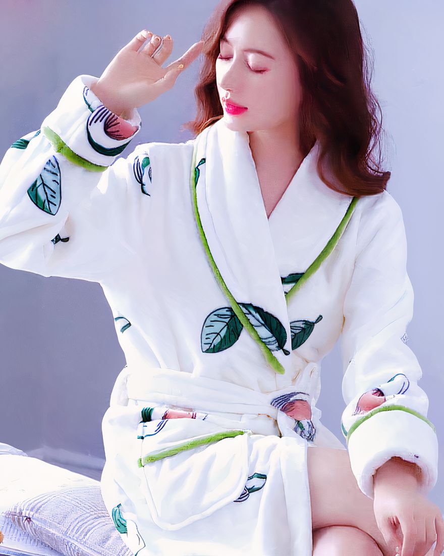 Coral fleece nightgown with leaf pattern worn by a woman sitting on a bed