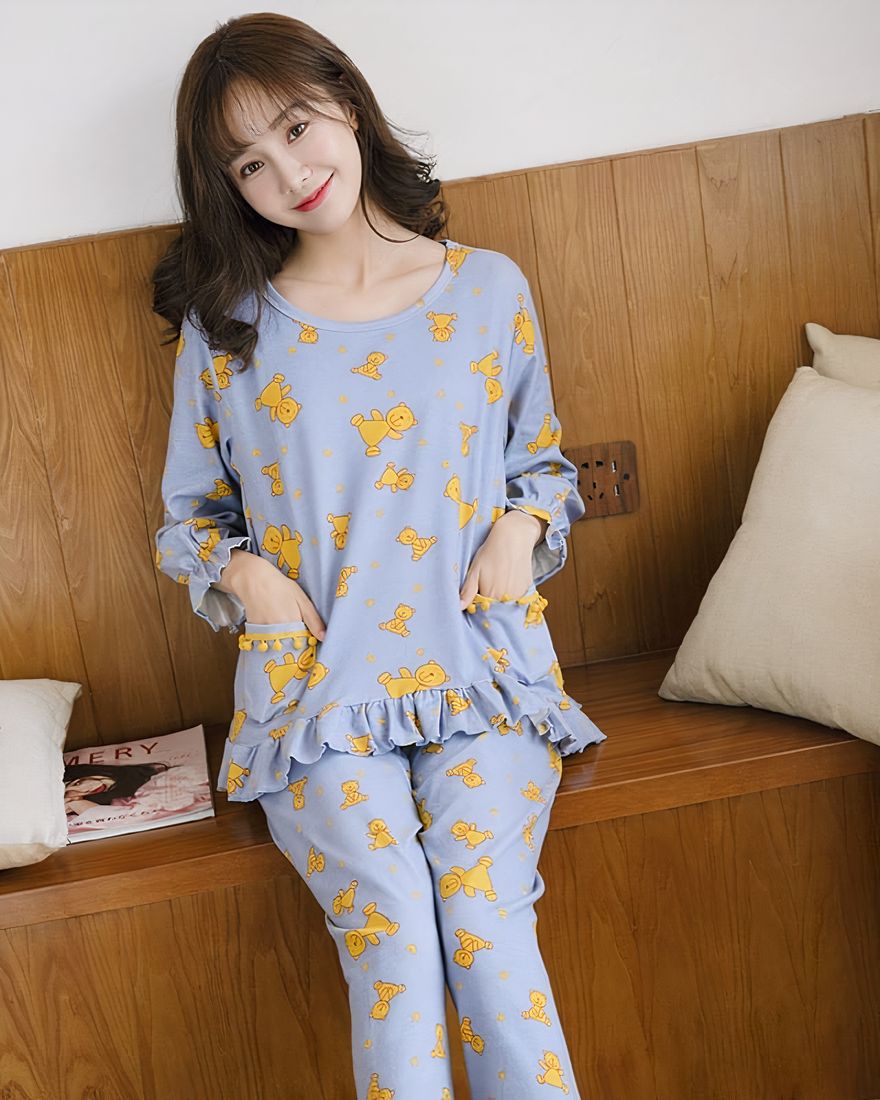 Giraffe and blue hippopotamus fall pajamas with long sleeves worn by a woman sitting on a chair