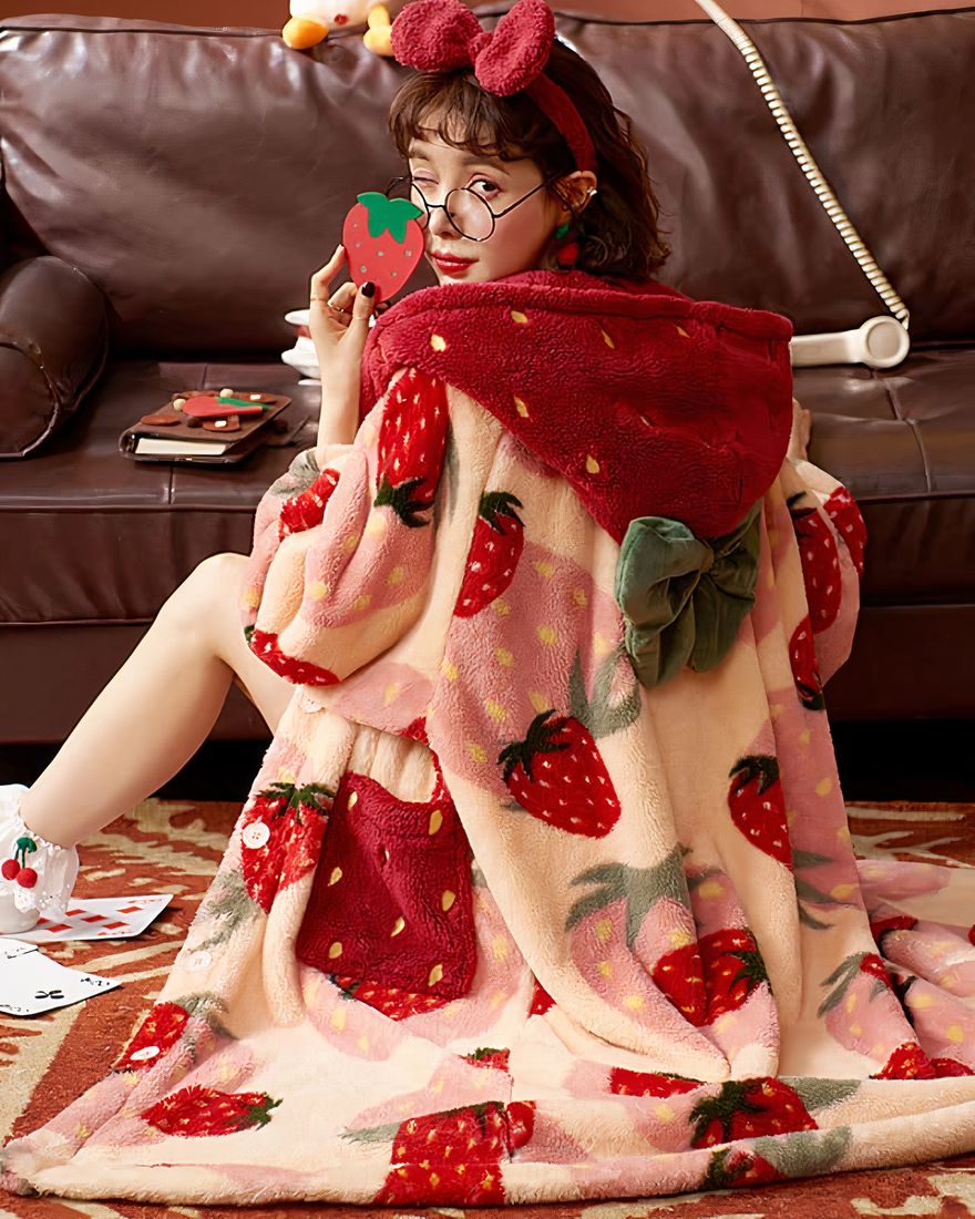 Long polar pyjamas with strawberry pattern for women with a woman wearing the colored pyjamas with a background a sofa