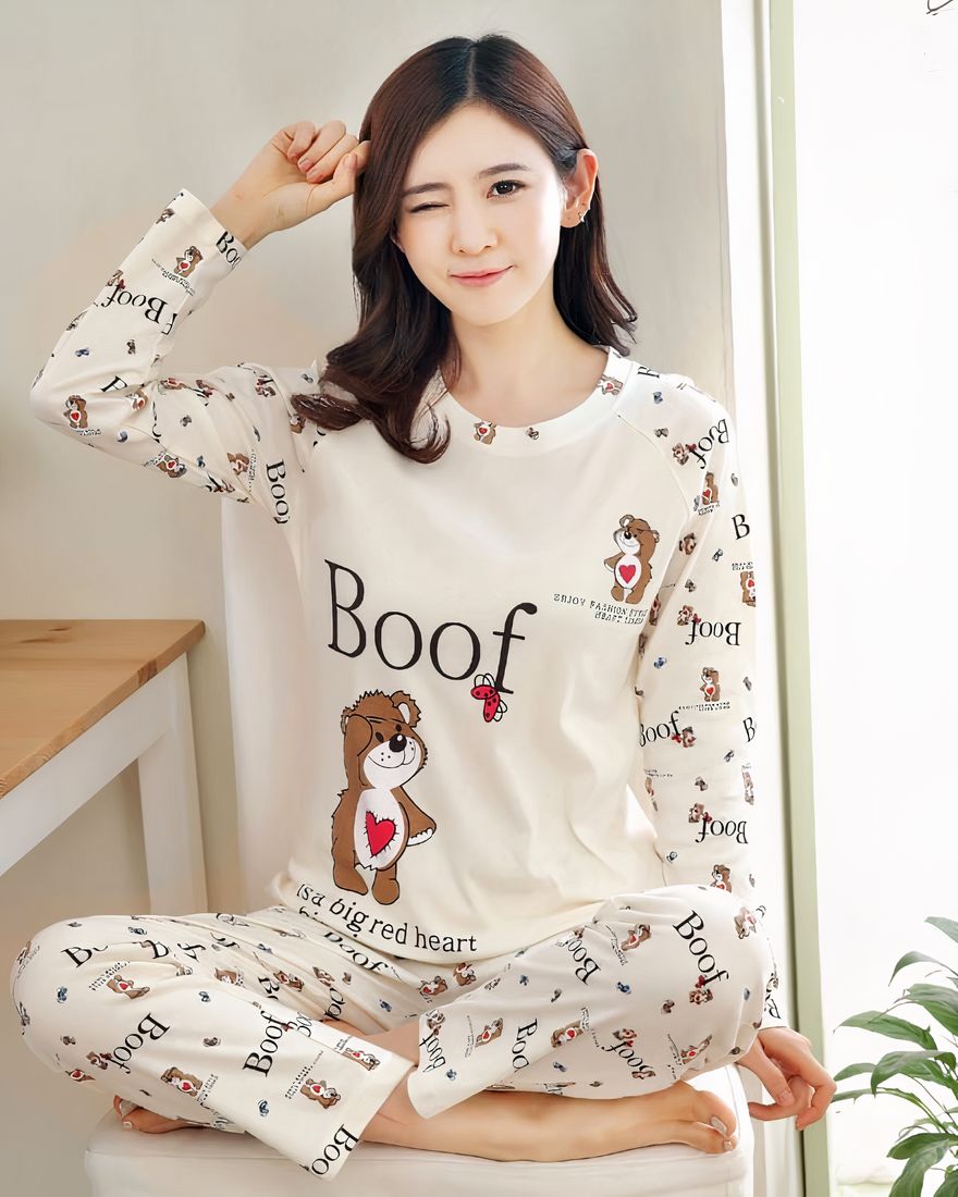 White fall pajamas with Boof pattern for women with a table background with a plant and a woman wearing the pajamas