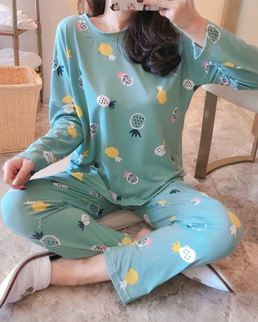Pineapple pattern fall pajamas for women worn by a woman sitting on a carpet