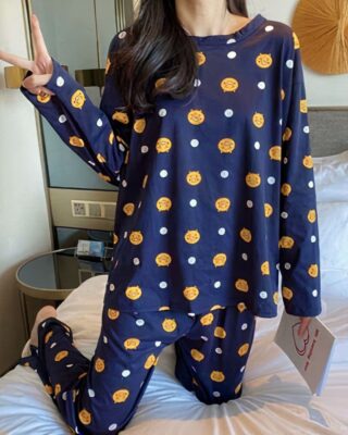 Long sleeve fall pajamas with blue emoji design worn by a woman in a house