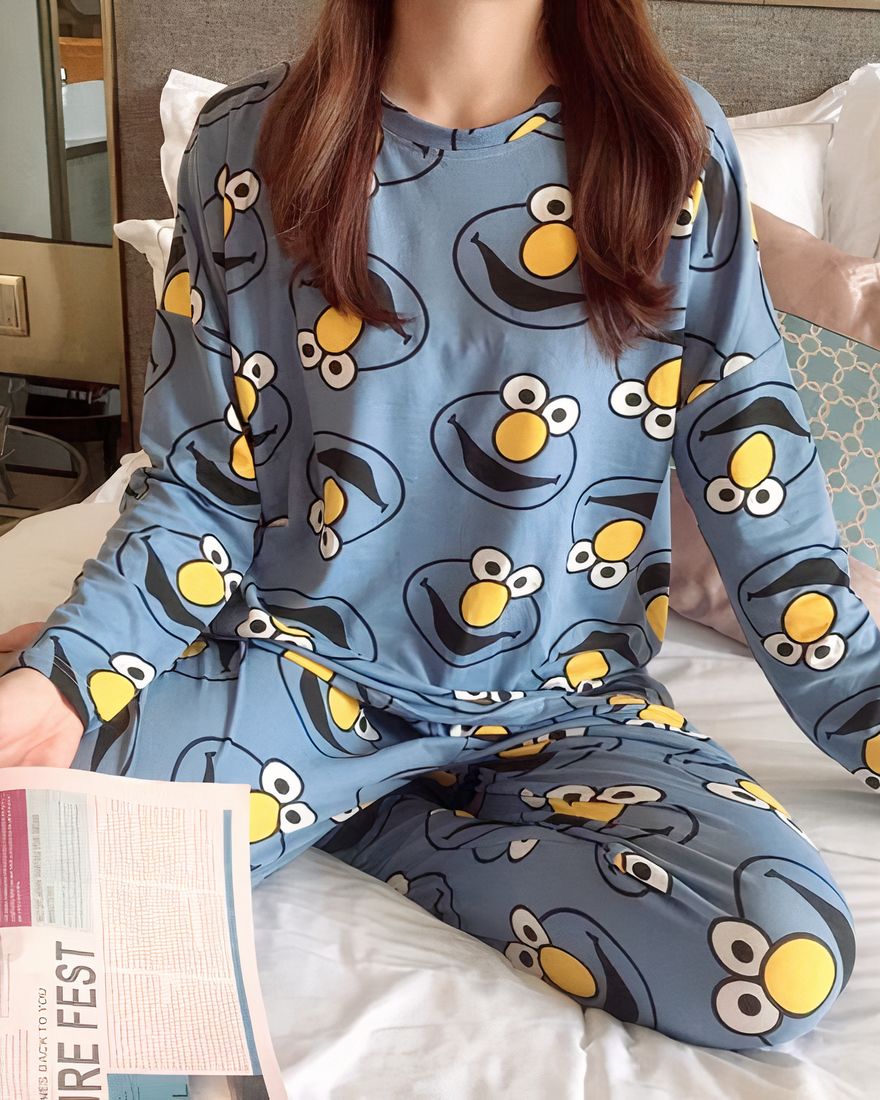 Long sleeve fall pajamas with Elmo print worn by a woman sitting on a bed in a house