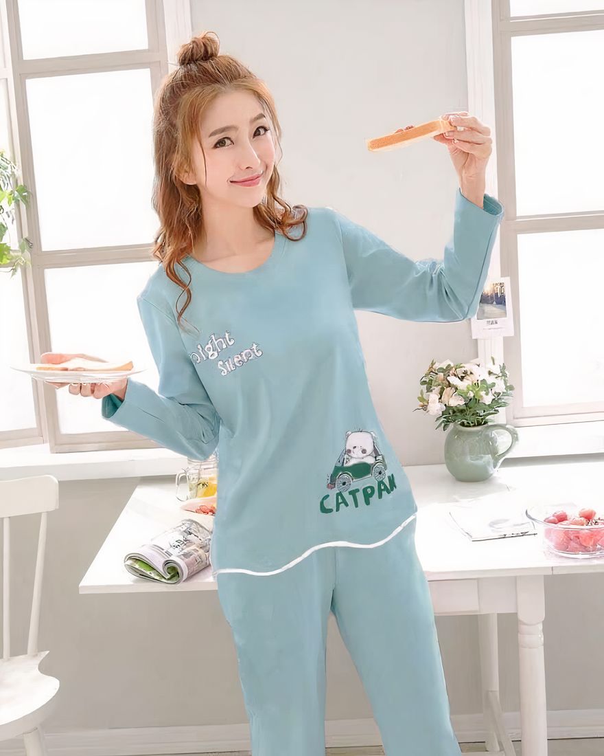 Blue two-piece long-sleeved pajamas for woman worn by a woman with a dining table and a chair in a house
