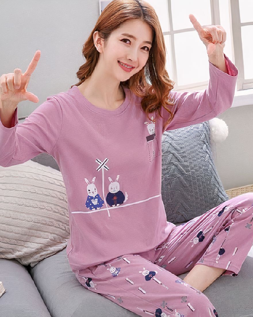 Purple long-sleeved pajamas with rabbit pattern for women worn by a woman sitting on a chair in a house