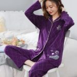 Two-piece purple pyjamas with geometric patterns a woman wearing purple pyjamas, with a background a room