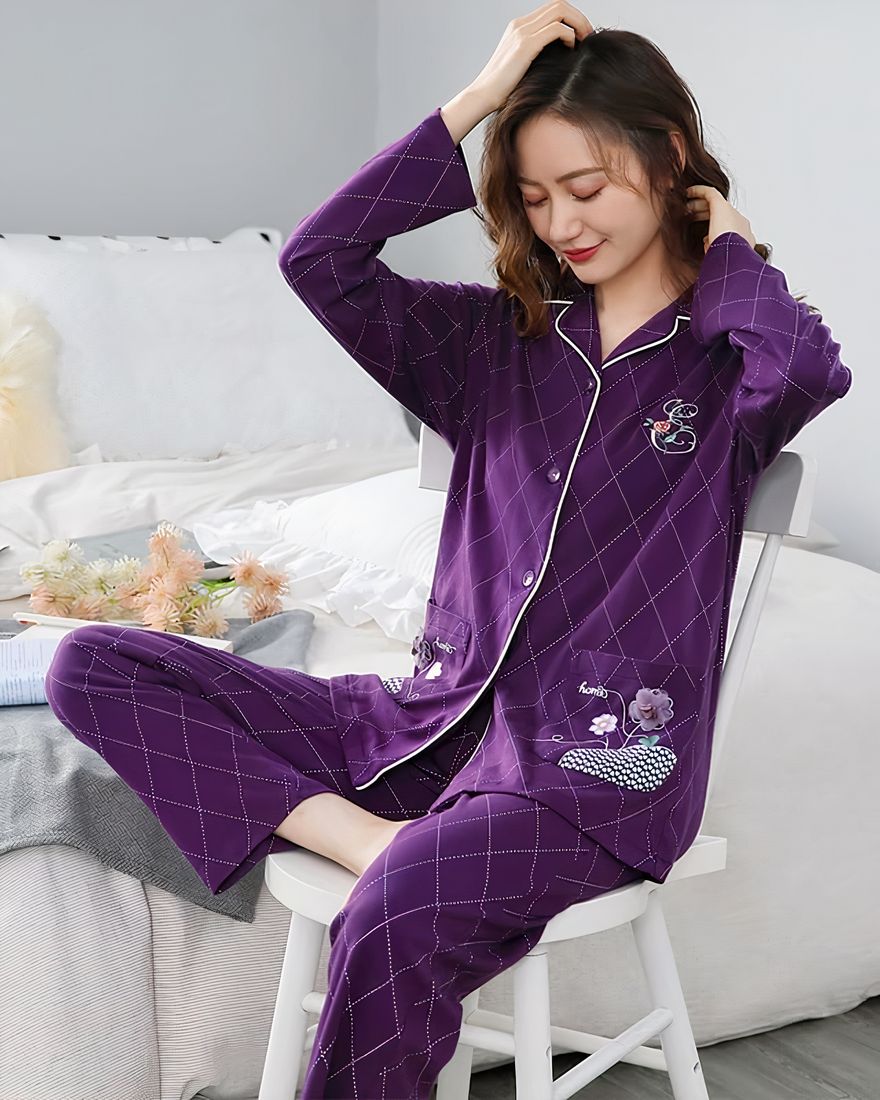 Two-piece purple pyjamas with geometric patterns a woman wearing purple pyjamas, with a background a room