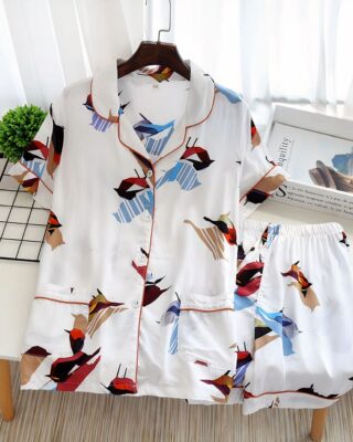 White short sleeve summer pajamas with bird print for women on a table with a magazine as decoration