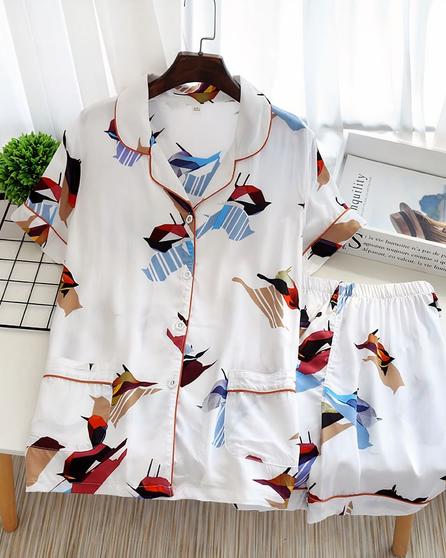 White short sleeve summer pajamas with bird print for women on a table with a magazine as decoration