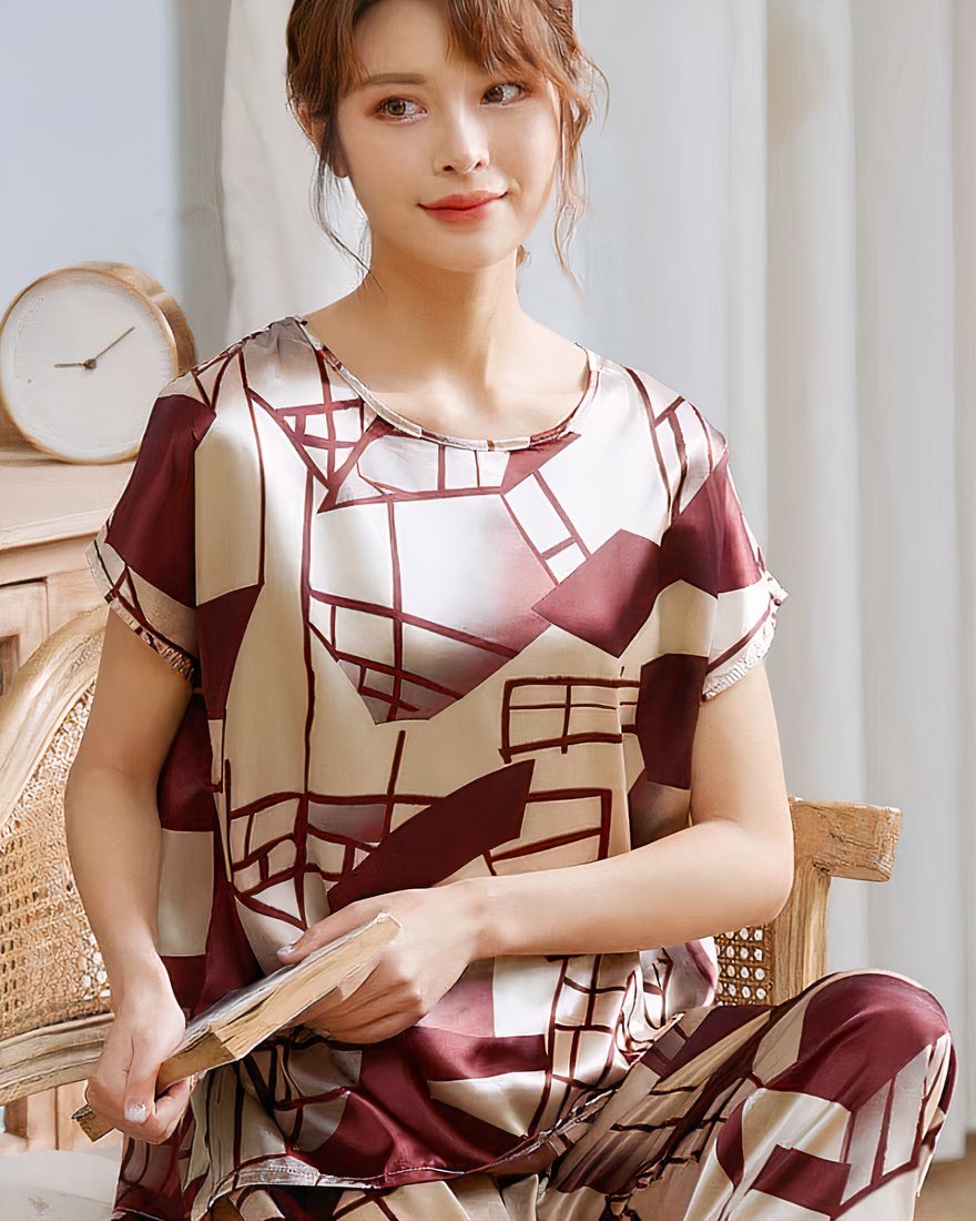 Deluxe two-piece short sleeve pajamas for women worn by a woman sitting on a chair in a house