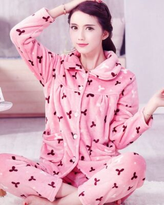 Pink woman's thick warm fleece pajamas worn by a woman sitting on a carpet in a house