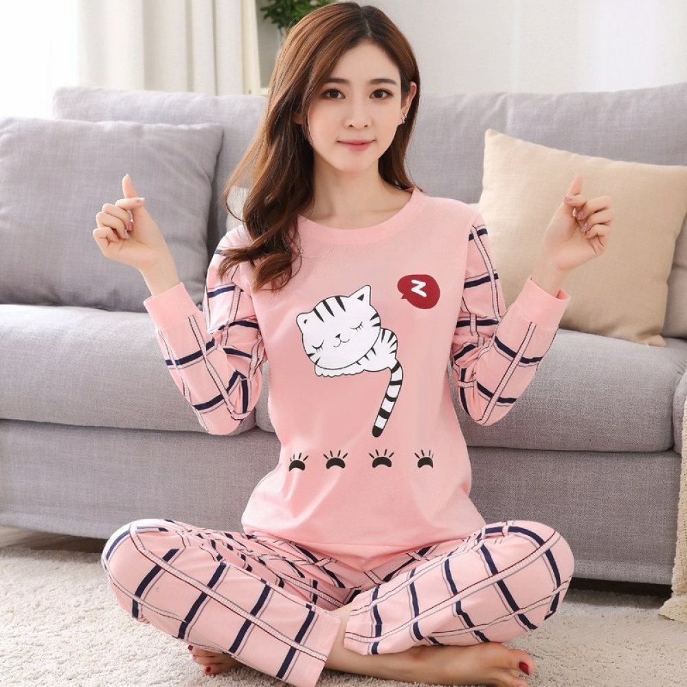 Cute 2-piece long sleeve pajamas for women worn by a woman sitting on a carpet in front of a chair in a house