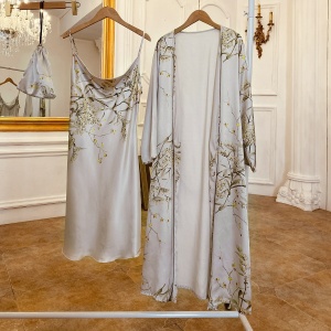 Sexy grey pyjamas with floral print hanging on a hanger in a room with wooden floor and white wall and in front of a large mirror with golden frame