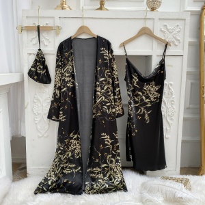 Sexy black pajamas with floral print hanging on hangers in front of a white wall with moldings and on a white fur blanket