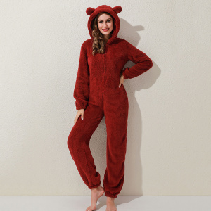 Fleece pajama suit in red color worn by a woman in front of a beige wall
