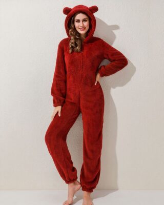 Fleece pajama suit in red color worn by a woman in front of a beige wall