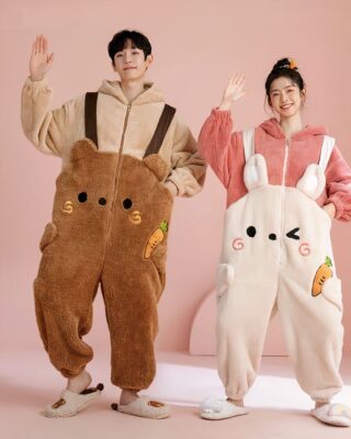 Pajama suit with hood in brown and beige worn by a woman and a man in a pink room