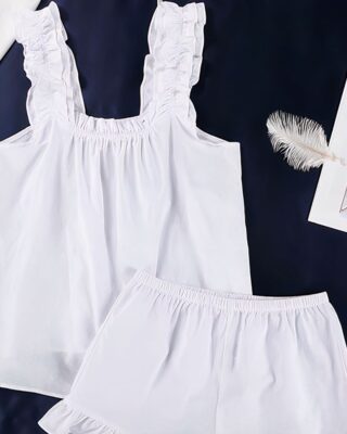 White cotton summer pajamas with shorts on black background