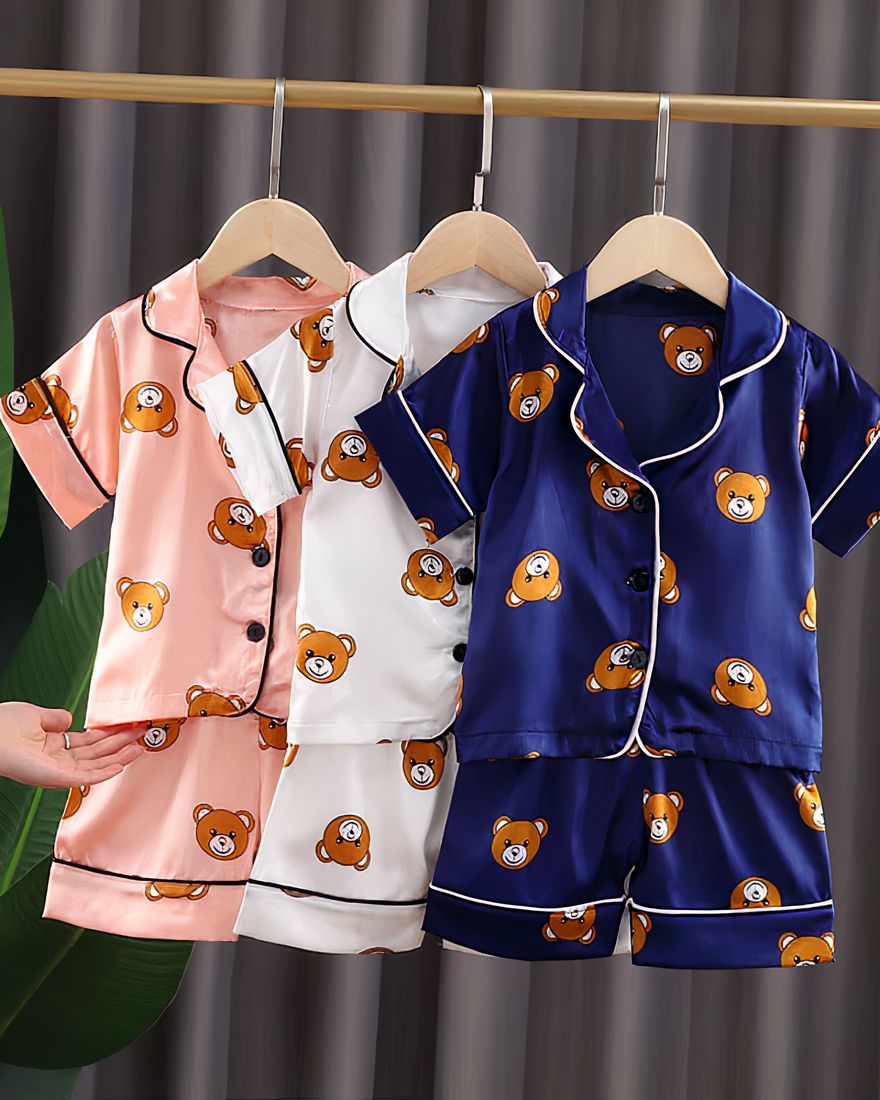 Three children's pajamas on a hanger with pink, white and blue bear motifs