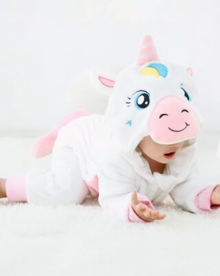 Baby on all fours in a white pyjama suit looking at his hands